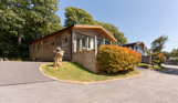 A row of lodges on a lodge park surrounded by trees on a sunny, blue sky day