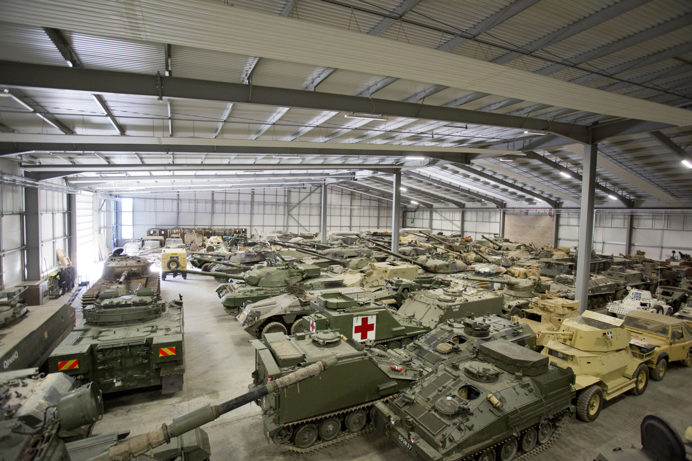 Inside a warehouse section of The Tank Museum filled with various historic fighter tanks on display