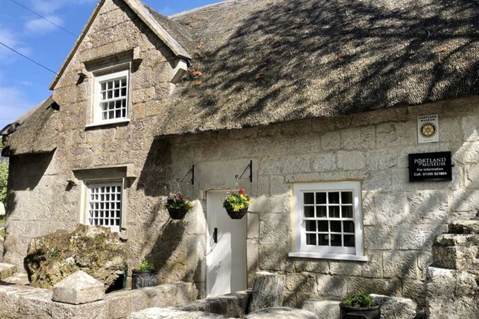 The outside of Portland Museum, within a thatched cottage building