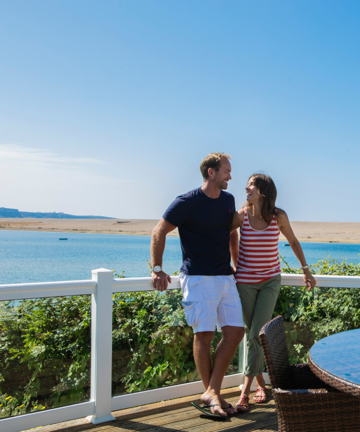 Relaxed couple on deck at CB with view in background