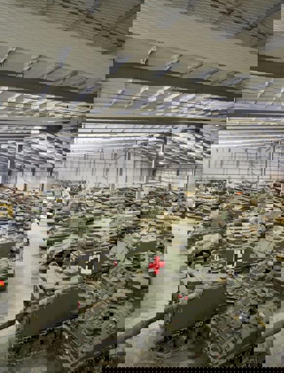 A large warehouse with a selection of old tanks