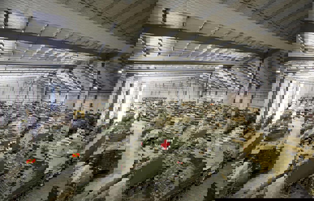 A large warehouse with a selection of old tanks