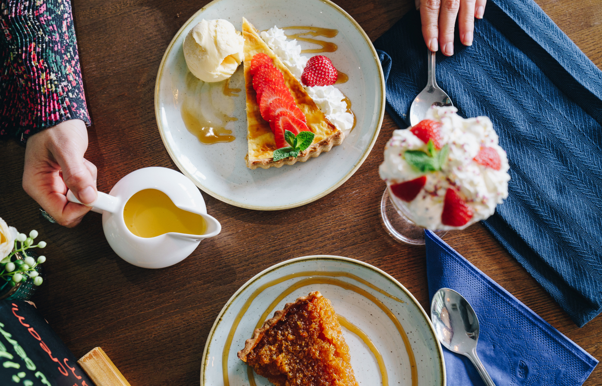 A selection of desserts including an ice cream sundae and a treacle tart taken from above