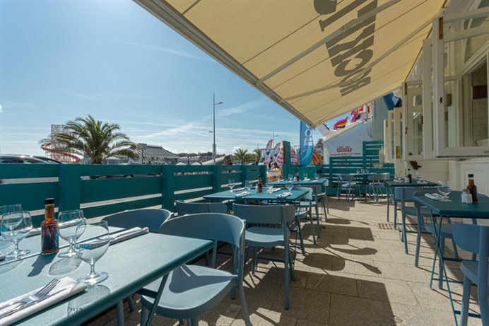 The outside of a Rockfish restaurant in Weymouth overlooking Weymouth Bay with blue skies