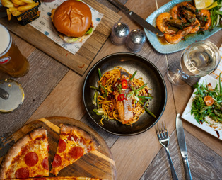 A selection of dishes from Breeze Bar & Grill including pizza, prawns, burger and noodle bowl