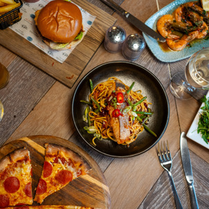 A selection of dishes from Breeze Bar & Grill including pizza, prawns, burger and noodle bowl