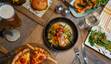 A selection of dishes from Breeze Bar & Grill including pizza, prawns, burger and noodle bowl