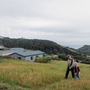 Family walking next to Seaton Sands development with valley views behind them