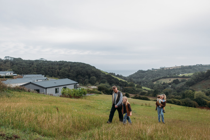 Family walking next to Seaton Sands development with valley views behind them