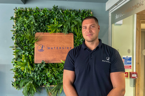 A smiling man stood beside a Waterside sign