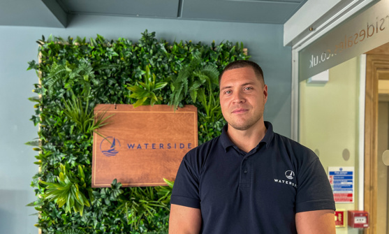 A smiling man stood beside a Waterside sign