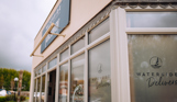 The outside of a fish and chip and pizza takeaway shop with 'Waterside Delivers' stickers on the windows