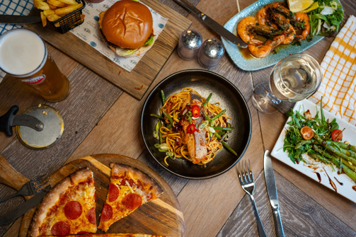 A range of different food items on a rustic looking table taken from above