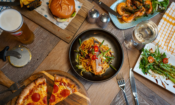 A range of different food items on a rustic looking table taken from above