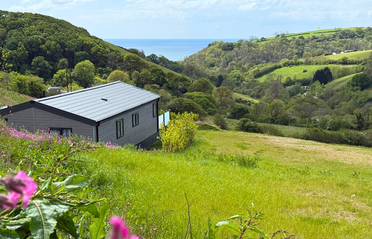 View of the sea from an area of Tregoad Holiday Park within the countryside valley
