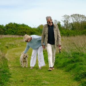 A couple on a walk on a countryside trail with a dog