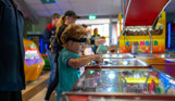 A young boy at the penny machines in Southside Arcade