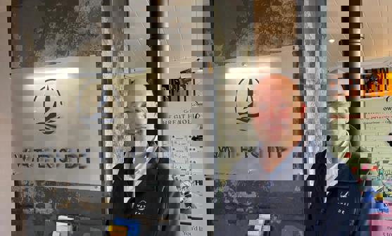 A smiling man stood beside a Waterside sign