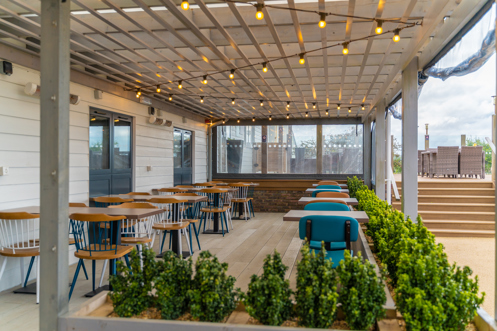 Outdoor seating under a terrace at Breeze Bar & Grill within Chesil Beach Holiday Park 