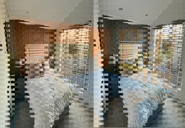 Master bedroom with wood panelling and muted tone decor