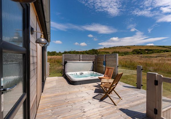 External of a cabin with decking, hot tub and outdoor furniture