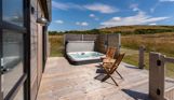 External of a cabin with decking, hot tub and outdoor furniture