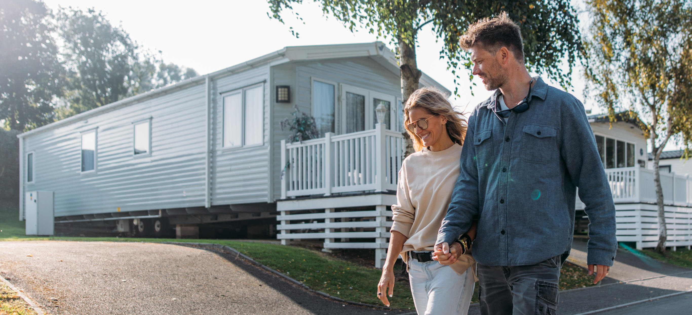 Couple walking down lane between caravans on-park
