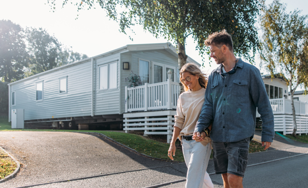 Couple walking down lane between caravans on-park
