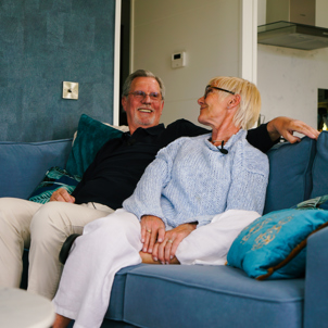 A couple on a sofa together looking lovingly at each other