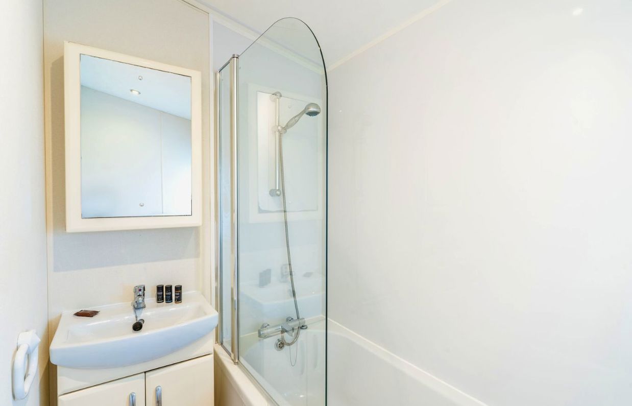 Internal of a caravan bathroom with shower over bath and sink