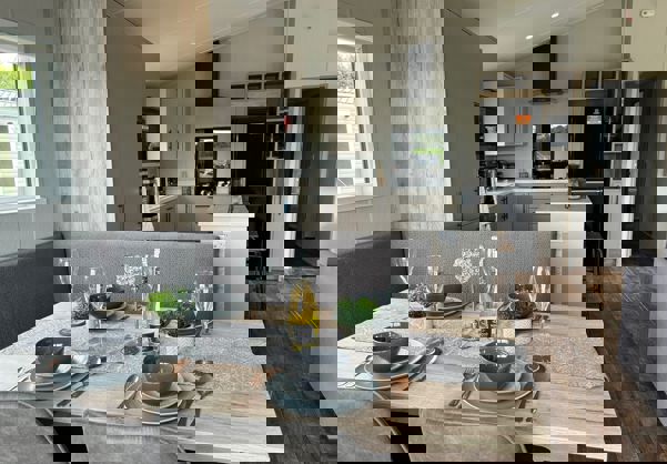 Dining table set for dinner for four people with a view through to kitchen