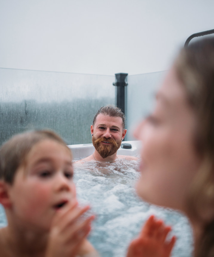 Dad watching kids have fun in hot tub
