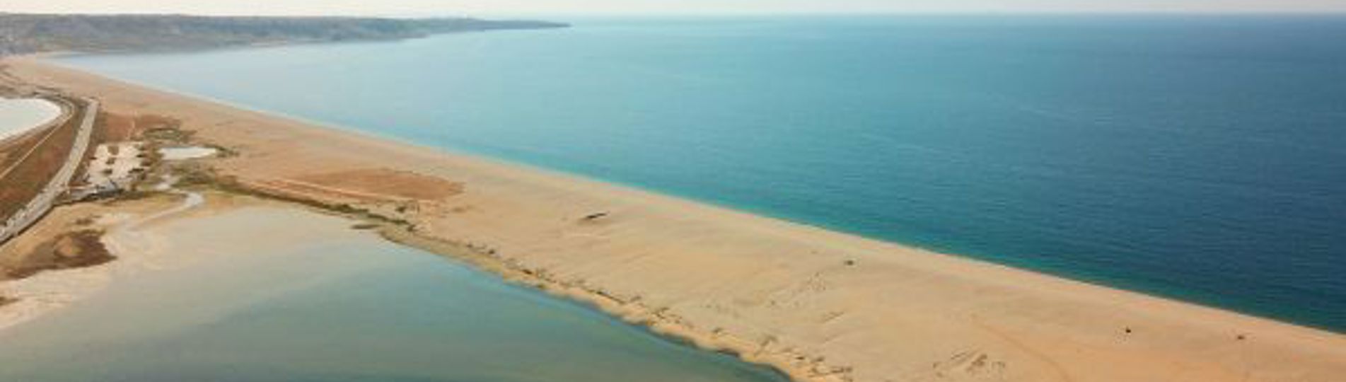 Aerial view of a stretch of Chesil Beach looking out towards the sea and Portland