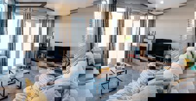 View of lounge with L-shape sofa, fireplace and TV