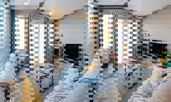 View of lounge with L-shape sofa, fireplace and TV