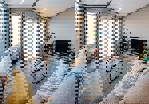 View of lounge with L-shape sofa, fireplace and TV