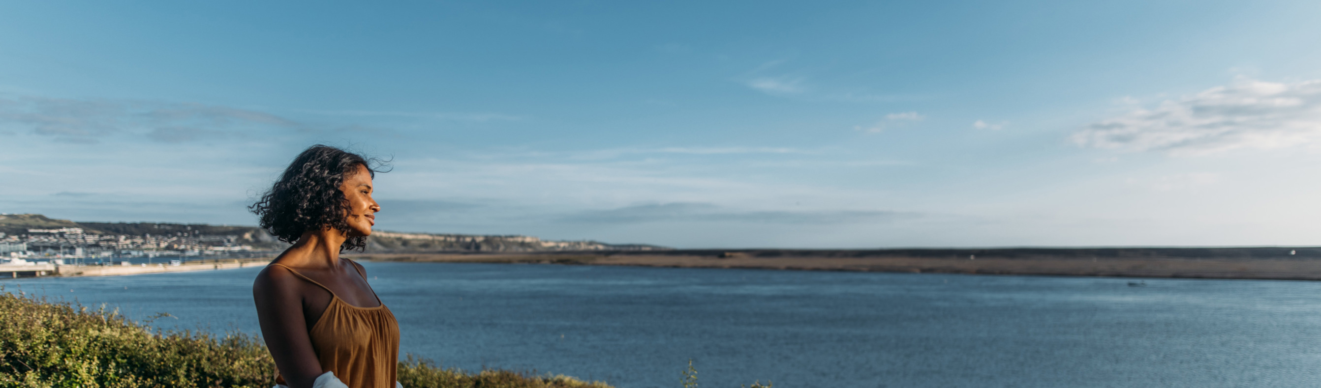 Woman admiring view of Chesil Beach from her holiday home