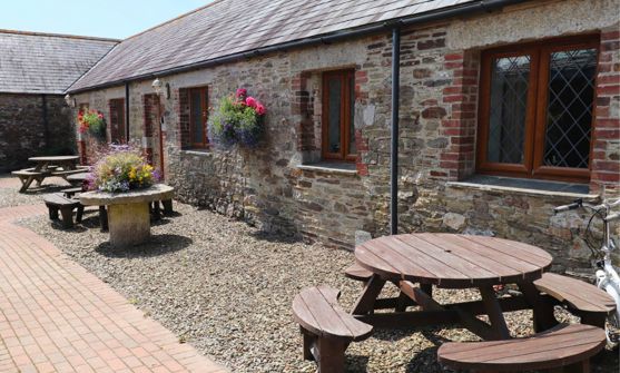 External of a cottage courtyard area with outdoor benches and flowers