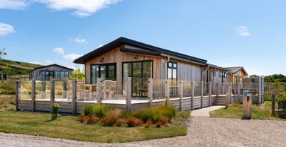 External of a luxury lodge with decking and outdoor furniture