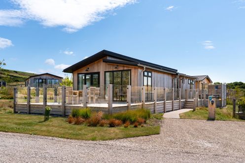 External of a luxury lodge with decking and outdoor furniture