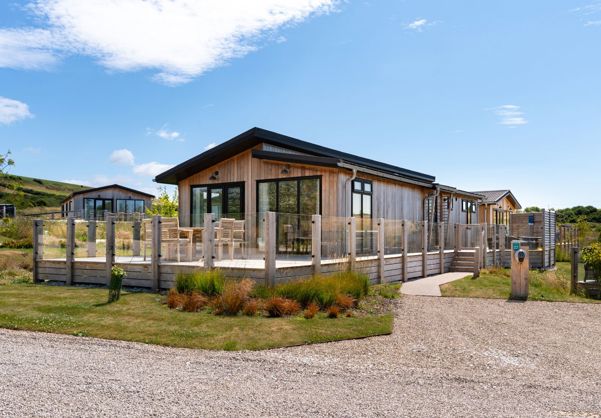 External of a luxury lodge with decking and outdoor furniture