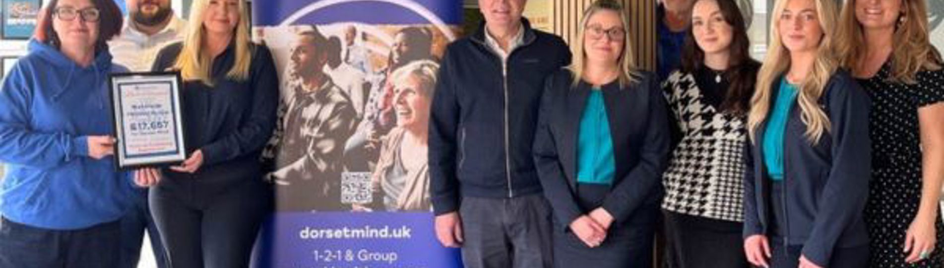 A group of people stood together smiling at the camera with Dorset Mind