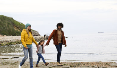 Family walking on beach in autumn