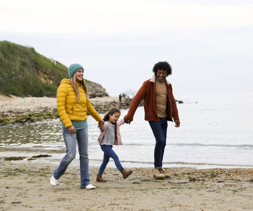 Family walking on beach in autumn