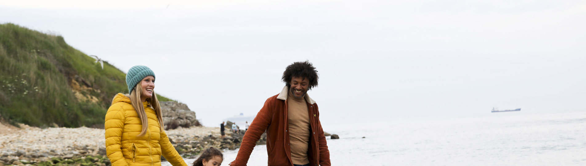 Family walking on beach in autumn