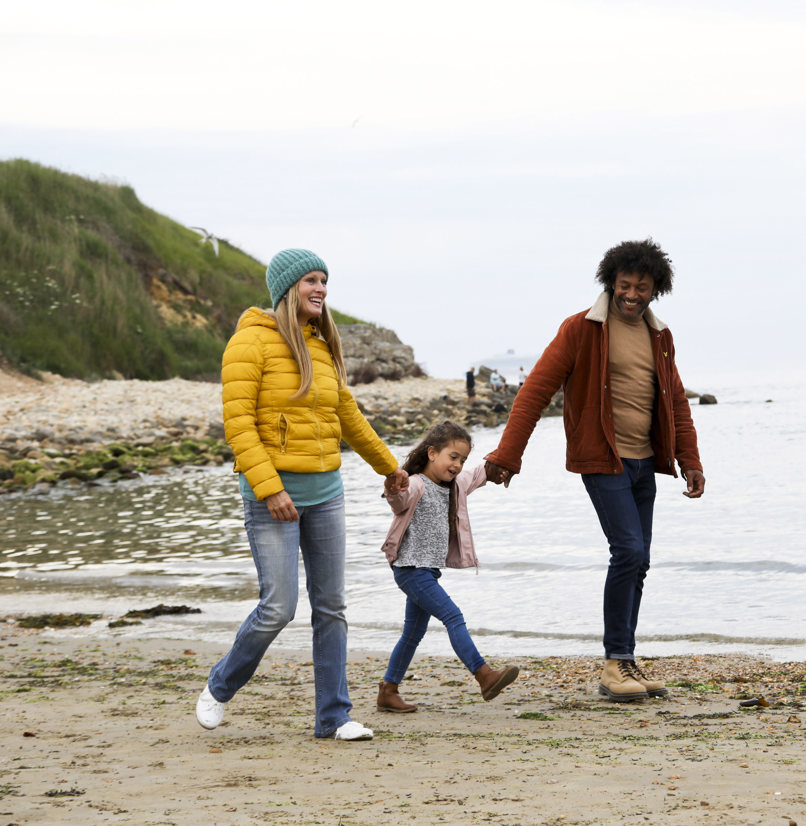 Family walking on beach in autumn