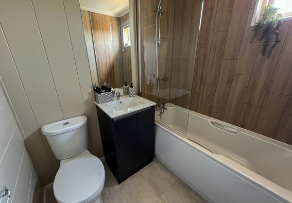 Internal of a luxury lodge bathroom with shower over bath toilet and sink