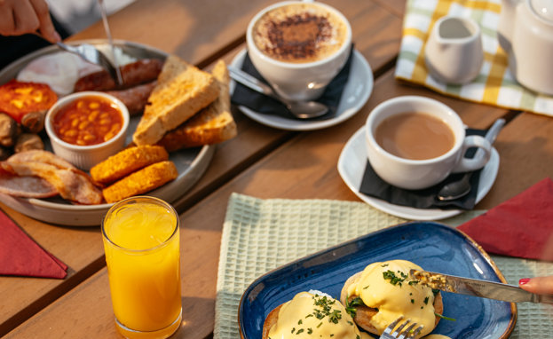 Two Breakfast Dishes with Hot Drinks and Orange Juice