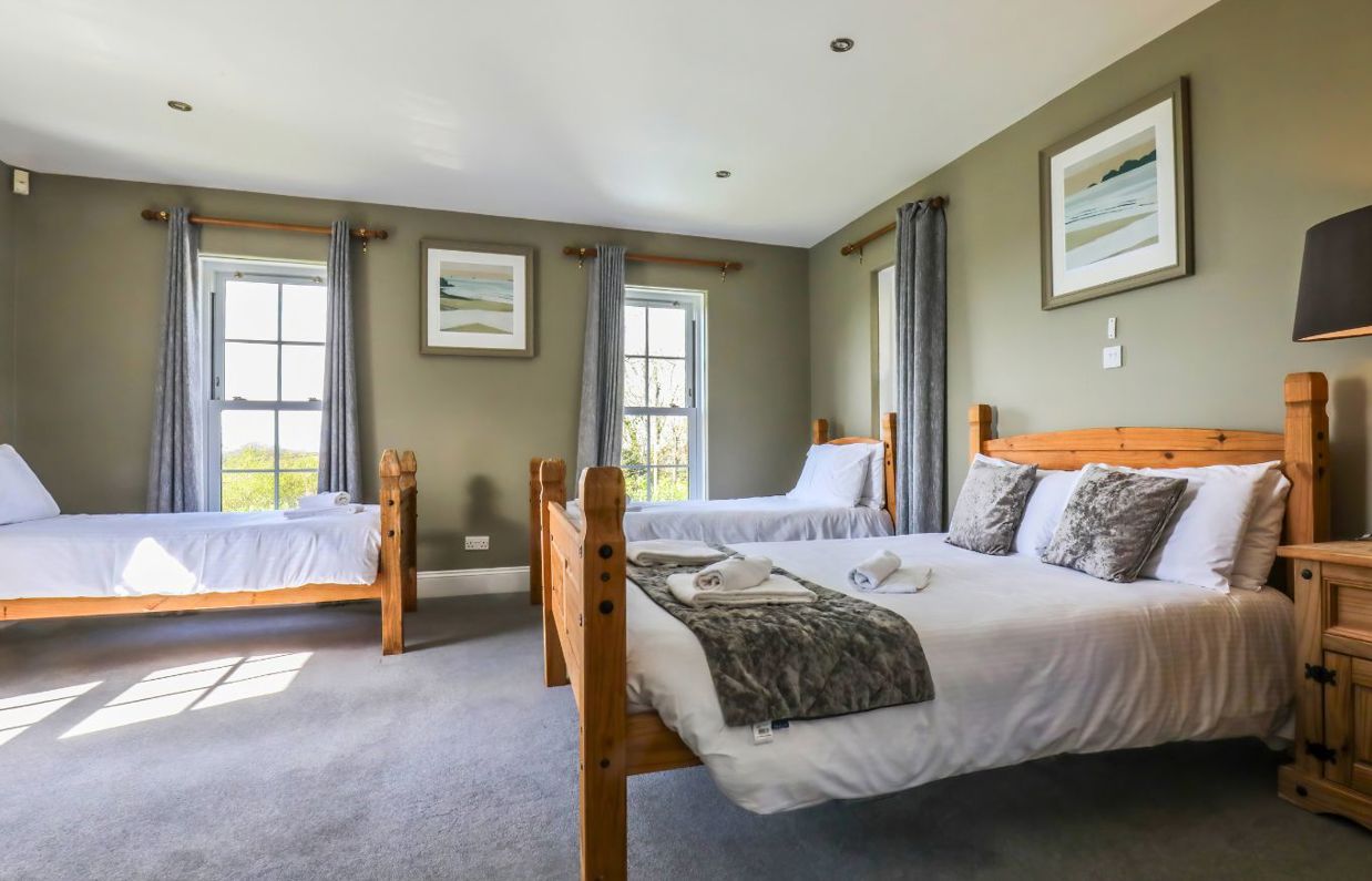 Internal of a manor house bedroom with double bed and two twin beds