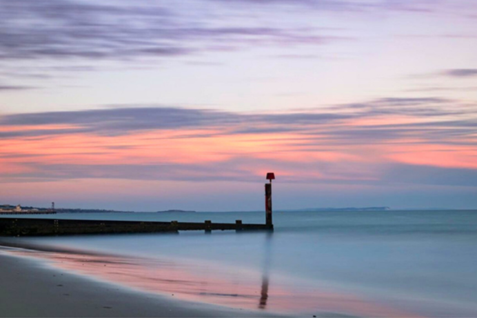 A calm, serene beach at sunrise